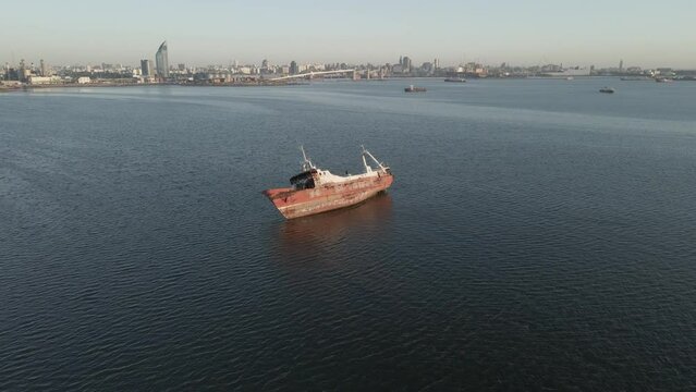 Barco encallado en el mar frente a una ciudad 1 