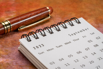 September 2023 - closeup of a small desktop calendar with a pen, time and business concept