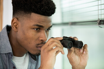 close view of man at window with binoculars
