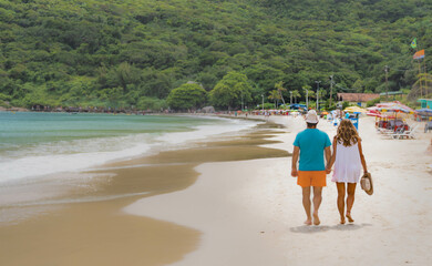 couple, walking and enjoying the sun on the beach