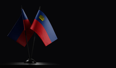 Small national flags of the Liechtenstein on a black background