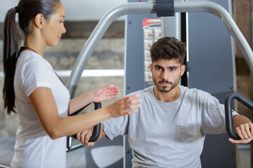 gym trainer observing a client