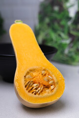 Butternut squash sliced in half on white background, front view shot of a butternut squash that has been cut in half with all de details