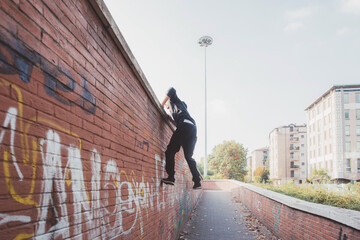 Athletic acrobatic man doing parkour trick training outdoors