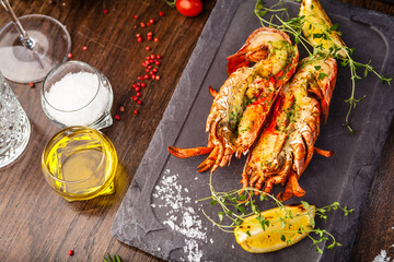 Lobster with flavored butter. Herb butter, lemon. Delicious healthy traditional food closeup served for lunch in modern gourmet cuisine restaurant - 562442963