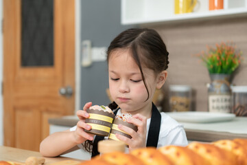Portrait of a little girl in the kitchen of a house having fun playing baking bread