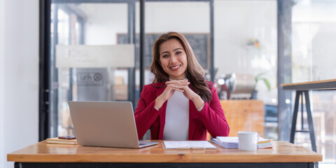 Portrait of Smiling asian business woman with laptop computer in office. Woman in suit at office