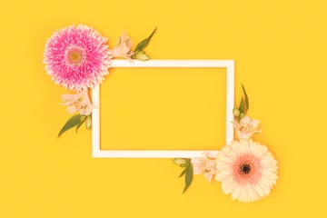 Foto auf Acrylglas Antireflex Frame made of green leaves, alstroemeria and gerbera flowers on a yellow background. © rorygezfresh