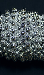 Shiny balls of a long beads are wound on a roll closeup stock photo
