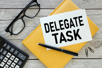 delegate tasks yellow notepad. torn paper with text. near glasses and calculator
