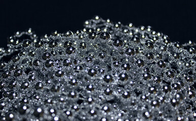 Silvery balls folded in a bunch sparkle under illumination from above soft focus stock photo
