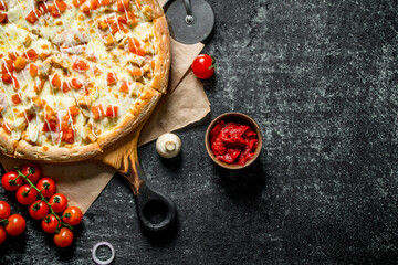 Fototapeta na wymiar Hot pizza on paper with cherry tomatoes.