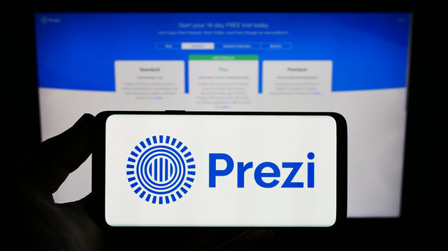 Stuttgart, Germany - 01-13-2023: Person holding smartphone with logo of Hungarian software company Prezi Inc. on screen in front of website. Focus on phone display.