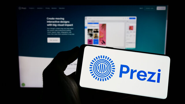 Stuttgart, Germany - 01-13-2023: Person holding mobile phone with logo of Hungarian software company Prezi Inc. on screen in front of business web page. Focus on phone display.