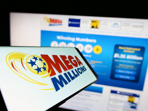 Stuttgart, Germany - 01-13-2023: Mobile phone with logo of American lottery Mega Millions on screen in front of website. Focus on center of phone display.