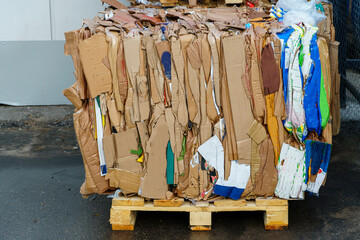 Stacked cardboard and paper products for further processing. A waste paper recycling company. Paper garbage at the recycling plant. Separate garbage collection.