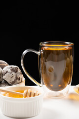 A cup of strong black tea, a glass large cup with a double bottom on a black background.