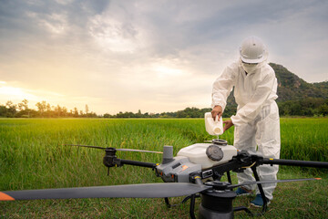 Agricultural specialist or Famer are filling chemical fertilizers in agriculture drone. Agriculture...