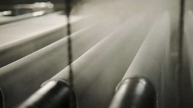 industrial workshop for the production of fiberglass fabric. factory. an automated conveyor processes the fiberglass fabric with steam. production