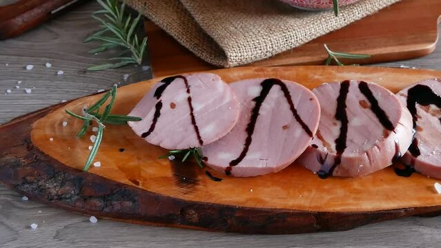 slices of Bologna IGP mortadella on a rustic wooden cutting board and Modenese tigelle