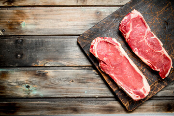 Raw beef steaks on cutting Board.