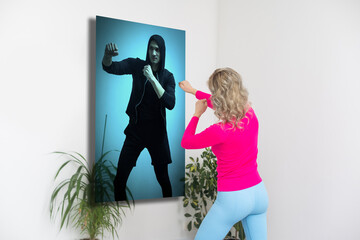 Fit woman in sportswear doing exercise mat at home using projector watching tutorial. Female coach...