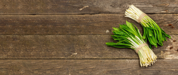 Bunches of fresh harvest of spring ramson, wild leek. Fragrant spicy leaves on vintage wooden table