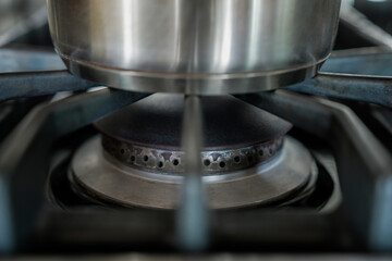 Stainless steel pot on unlit gas stove burner 