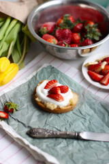 Sandwich with strawberries, soft cheese and balsamic vinegar on a light paper background. High quality vertical photo