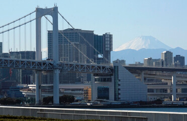 Rainbow Bridge going over Tokyo Bay in Tokyo, Japan, with mount Fuji in the background