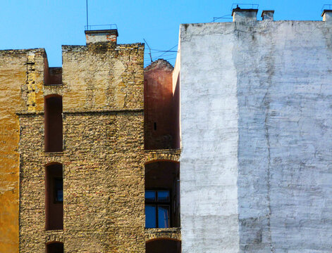 old deteriorating brick fire walls of multi storey residential buildings. architecture and construction concept. yellow and white painted clay brick texture. abstract frontal elevation view.