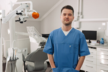 Horizontal portrait of a handsome hispanic male dentist posing at his clinic smiling to the camera joyfully copyspace medicine dentistry people wellbeing helpful friendly health teeth oral concept.