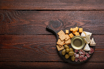 Toothpick appetizers. Pieces of sausage, cheese and honey on wooden table, top view with space for...