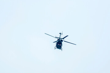 Fototapeta na wymiar helicopter flew away against blue sky background.