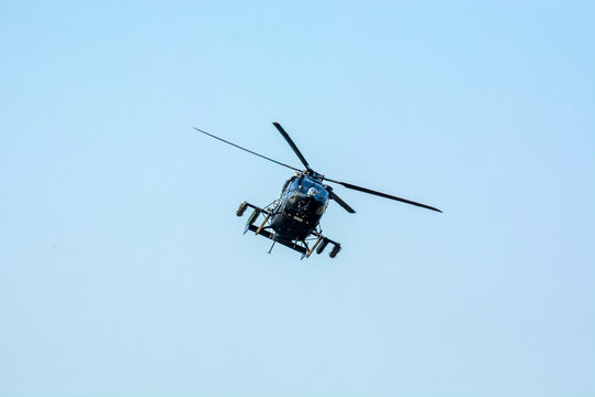 Combat helicopter is flying against isolated blue sky. combat helicopter attack enemy.