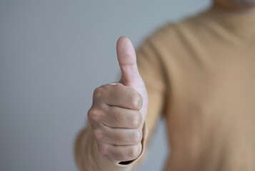 Close-up thumbs up to camera for advice or good choice Professional support and service teams demonstrate satisfaction and positive response.