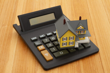 Mortgage calculator with a house on a wood desk