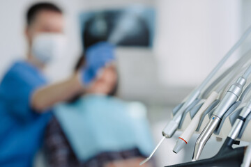 dental tools with dentist and patient on background.