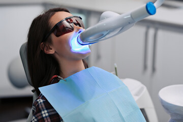 Teeth whitening for woman. Bleaching of the teeth at dentist clinic.