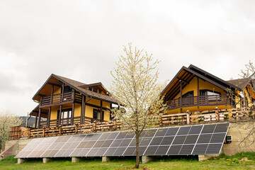 Solar batteries eco house green energy.Solar power plants in the field near the forest. An...