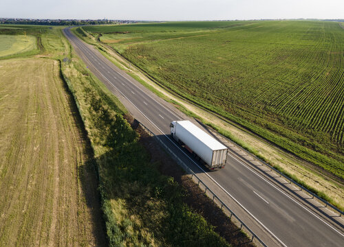 Truck with Cargo Semi Trailer Moving on Rural Road in Direction. Aerial Top View