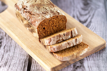 Loaf of bread on a board with cut pieces