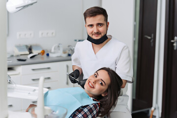 Fototapeta na wymiar The girl is at the reception at the dentist. A happy client at the dentist smiles. Dental bleaching. Dental clinic. Treatment of teeth in a modern clinic.