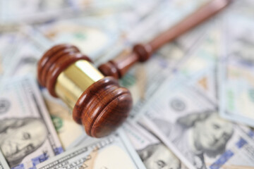 Judge gavel on dollars banknotes background, close up.