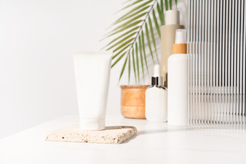 White blank plastic cosmetics, cream tube standing on a bathroom shelf. Studio photography.