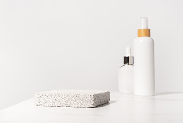 Cosmetic beauty product presentation scene made with pumice stone pedestal on a bathroom shelf in...