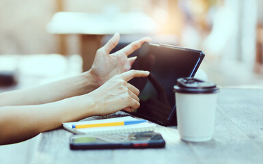 Asian freelance woman working and meeting on tablet computer on wooden table at outdoor cafe. Entrepreneur woman working for her new business concept.