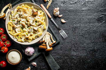 Fusilli pasta with mushrooms, tomatoes and garlic.