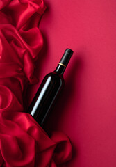 Bottle of red wine on a red background.