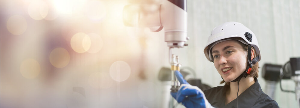 Female engineer control autonomous mobile robot in the manufacturing automation and robotics academy room. Woman engineer training or maintenance AI robot